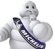 Michelin City Grip2 100/90-14 motorcycle tire with 57S speed rating, showing tread pattern and sidewall branding.